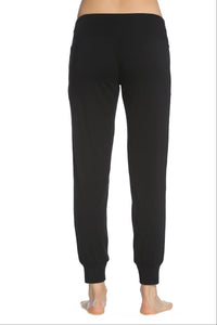 Back view of black Pima cotton lounge pants with wide waistband and cuffed ankles on model