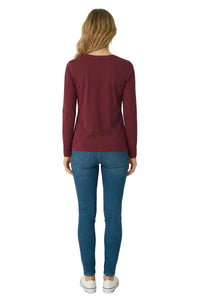Woman wearing a long sleeve burgundy loungewear top and blue jeans, back view