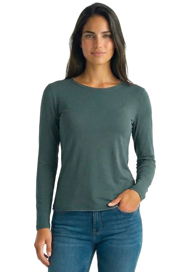 Woman in sage green long sleeve Pima cotton tee and blue jeans, relaxed fit, white background