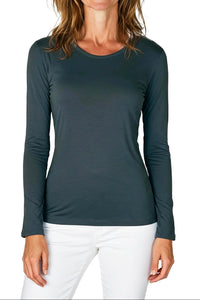 Woman wearing a dark gray long-sleeve shirt and white pants on a white background