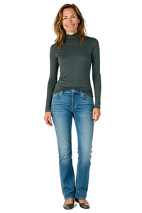 Woman wearing a green turtleneck and blue jeans on a white background