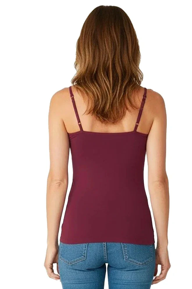 Woman in a bordeaux camisole with adjustable straps and blue jeans, back view