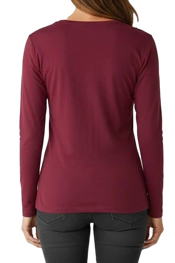 Person wearing a burgundy long-sleeve top and black pants on a white background