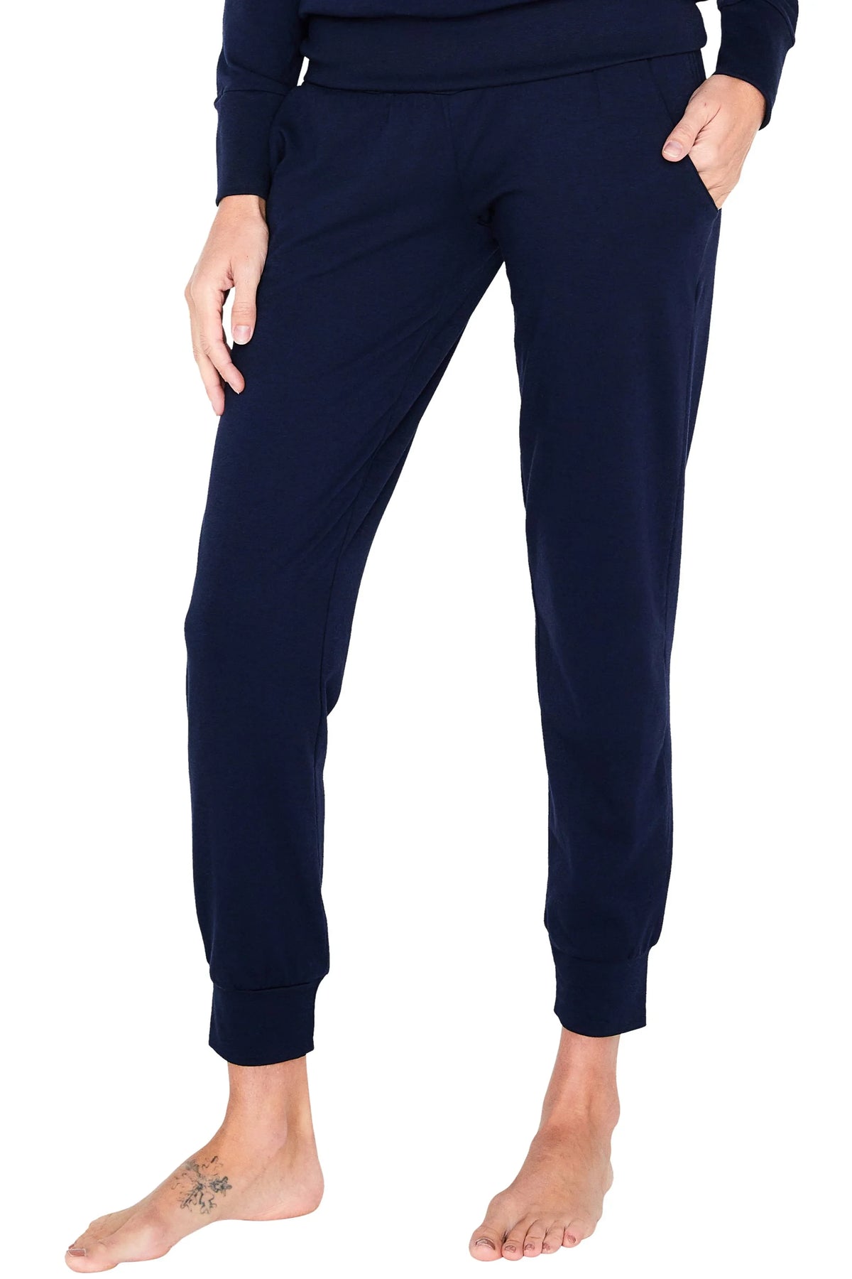 Woman wearing navy blue Pima cotton lounge pants with pockets, bare feet visible