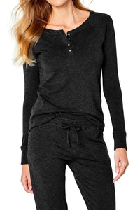 Woman wearing black long sleeve henley loungewear set with drawstring pants