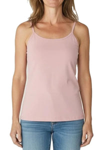 Woman wearing shell pink spaghetti strap tank top paired with blue jeans on white background