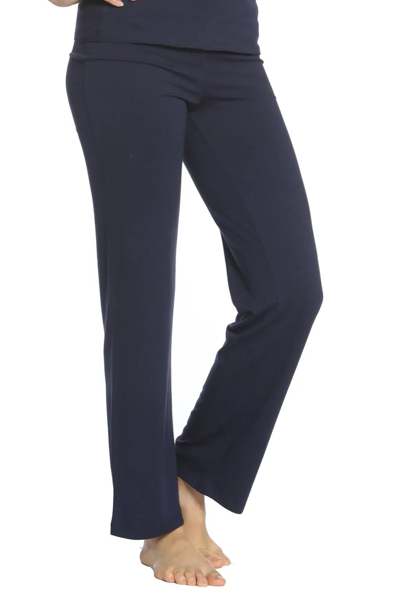 Woman wearing midnight blue yoga pants with a straight leg fit barefoot on white background