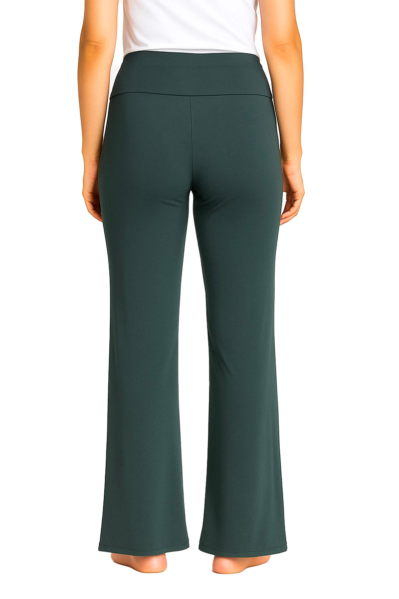 Back view of woman wearing dark green flare pants and white top, barefoot on white background