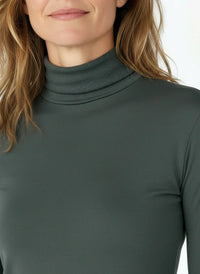 Close-up of woman wearing spruce green ribbed turtleneck top with long sleeves