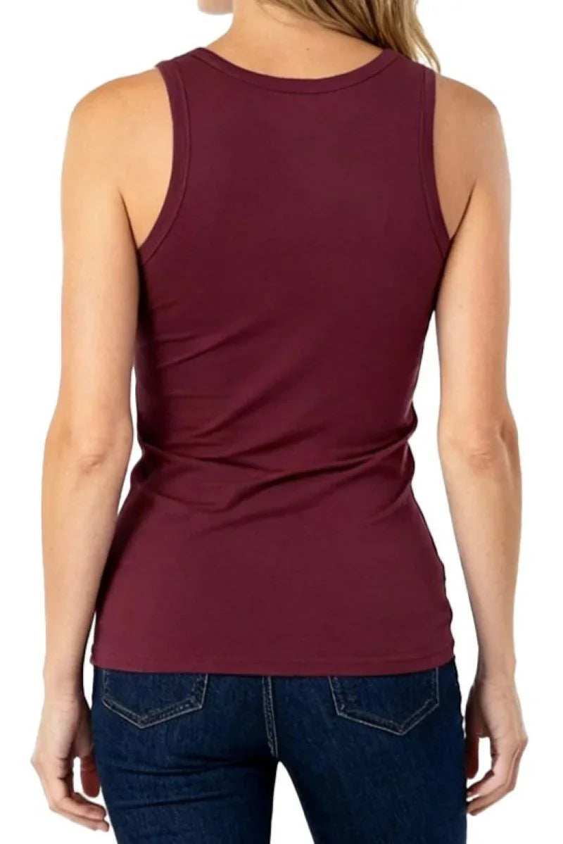 Woman wearing a maroon sleeveless tank top and dark blue jeans, back view