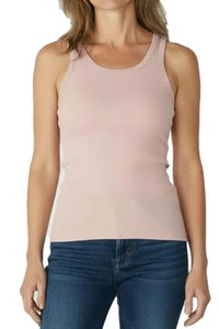 Woman wearing a shell pink sleeveless ribbed tank top with blue jeans against white background