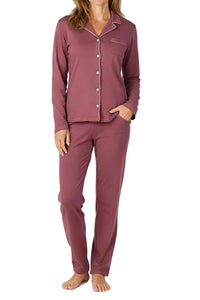 woman wearing rosewood pink long sleeve button-up pajama top with collar and matching pants standing barefoot