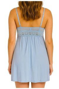 Back view of woman wearing light blue lace-trimmed sleeveless nightdress with adjustable straps