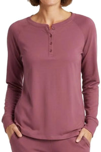 Woman wearing long-sleeve rosewood henley shirt with button placket and hands in pockets
