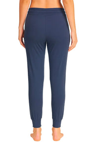 Back view of woman wearing steel blue jogger pants with ribbed cuffs and elastic waistband