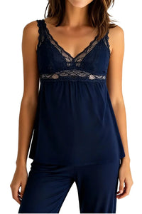 Woman wearing indigo lace-trimmed sleeveless pajama top with matching pants on white background